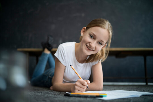 Girl lying on carpet and learning at home