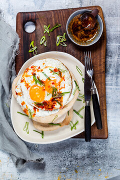 Flat bread with garlic yogurt, fried egg and chilli butter on chopping board