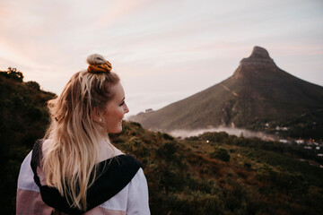 Obraz premium South Africa, Cape Town, Kloof Nek, smiling woman on a trip at sunset
