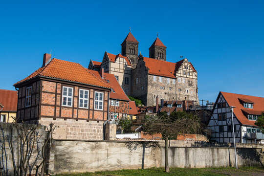 Germany, Saxony-Anhalt, Quedlinburg, Low angle view of Quedlinburg Abbey and surrounding half-timbered houses