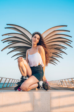 Young smiling woman with inline skates on waterfront promenade