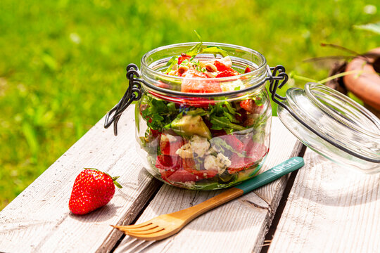 Strawberry avocado salad with feta, rocket and pine nuts in jar