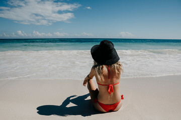 Mexico, Quintana Roo, Tulum, young woman with hat lying on the beach