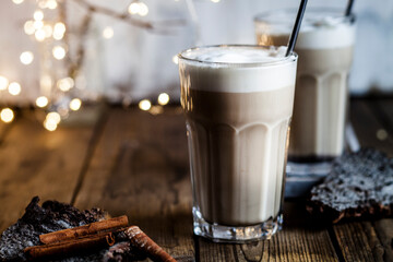 Glass of iced chai with frothy milk and cinnamon
