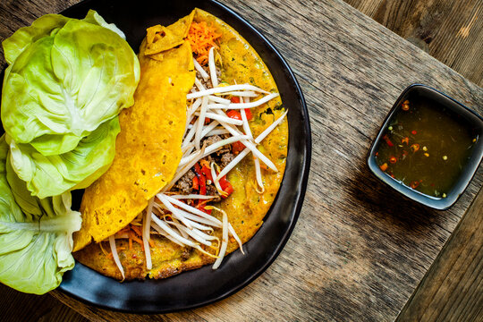 Banh xeo with lettuce and Nuoc Cham dipping sauce