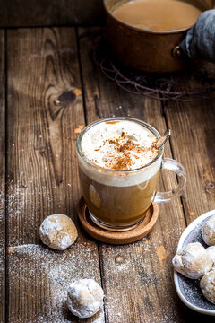 Pumpkin spice latte with a dollop of cream and some cookies