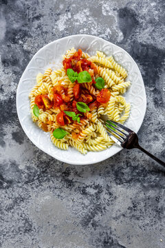 Plate of vegan pasta with tomatoes and basil