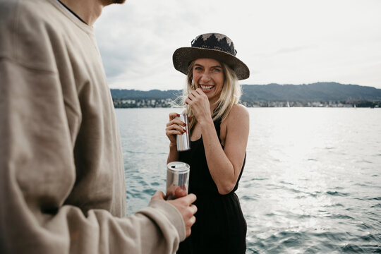 Happy young couple having a drink at a lake