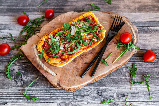 Homemade pizza with rocket, parma ham, tomato and parmesan