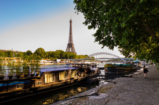Eiffel Tower by Seine river against clear blue sky during sunrise, Paris, France