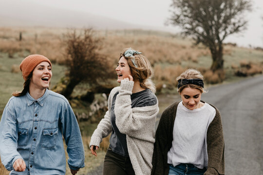 UK, Scotland, Isle of Skye, three happy young woman on a rural road