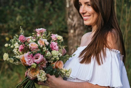 Smiling beautiful woman holding fresh flower bouquet