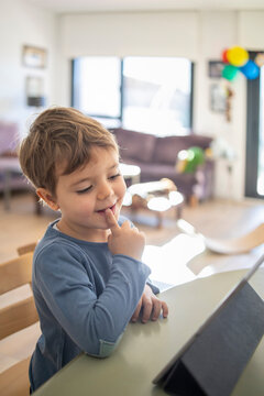 Boy using digital tablet during online class at home