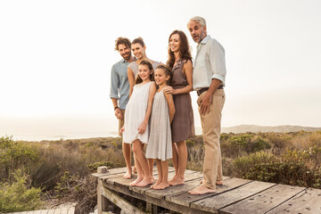 Large family enjoying the sunset standing on a boardwalk