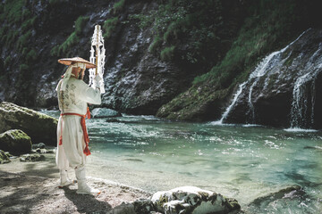 European yamabushi monk in traditional shugendo robe does water ceremony with gohei