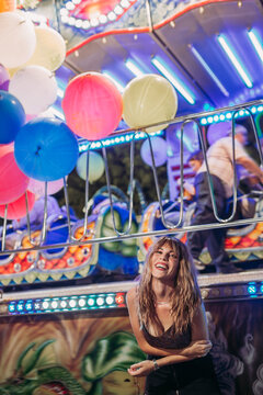Happy young woman on a funfair at night