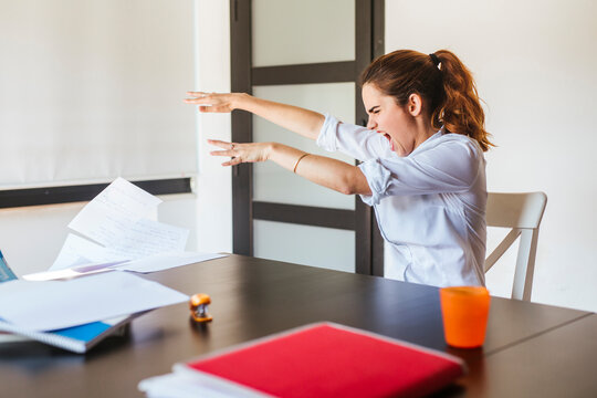 Angry female student at desk at home