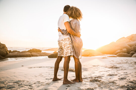Couple hugging on the beach enjoying the sunset