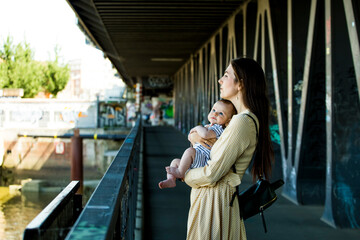 Mother with her baby baby on a bridge
