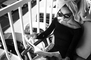 Glamour lady reading a magazine on balcony