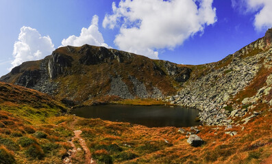 deep green mountain lake in the middle from colorful mountains panorama