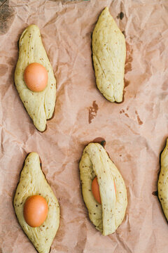 Directly above view of fresh brown eggs and dough on paper in kitchen