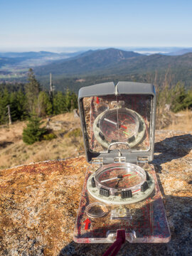 Navigational compass lying outdoors on rocky surface