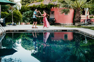 Man and women dancing by poolside
