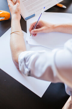 Close-up of female student learning at desk at home taking notes