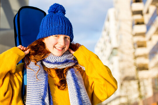 Smiling girl in warm clothing against sky