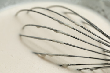 Metal whisk in the dough. Stirring whisk. Whisk in pancake mix.