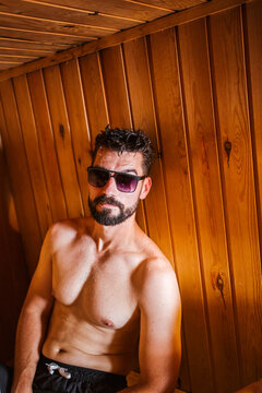 Portrait of a man wearing sunglasses in a sauna