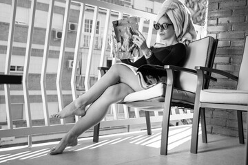 Glamour lady reading a magazine on balcony
