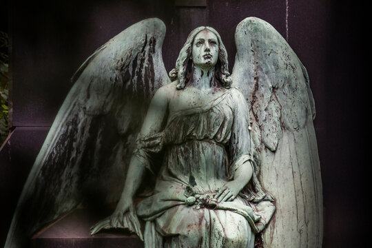 Weathered statue of sitting angel