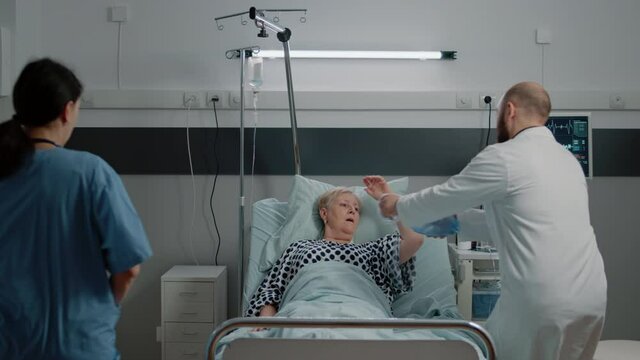 Sick woman hyperventilating and asking about medical assistance while doctor and nurse rushing to help with respiratory problem. Specialists using oxygen tube and oximeter for patient