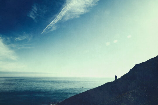 France, Normandy, Barneville-Carteret, Silhouette of hiker admiring sea from&Ocirc;&oslash;&Omega;Cape Carteret