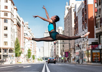 Ballet dancer dancing on road in city