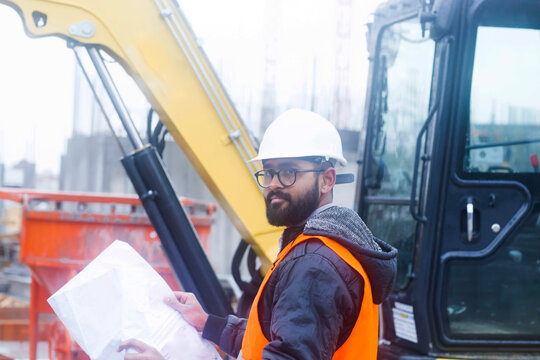 Construction engineer at construction site wearing hard hat and safety vest