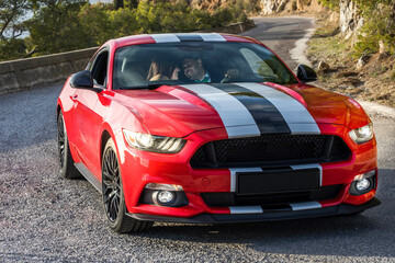 Adult couple sitting in red sports car, Spain