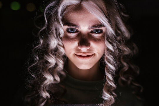 Portrait of smiling young woman in darkness