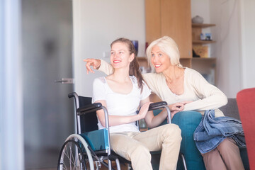 Mother with daughter in a wheelchair, pointing finger