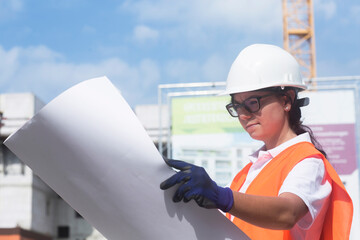 Female construction engineer looking at construction plan