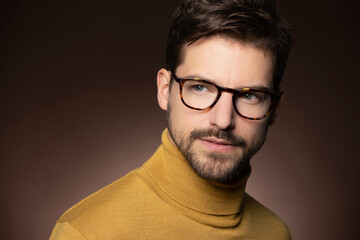 Portrait of confident man wearing glasses and yellow sweater