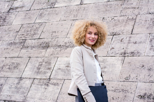 Portrait of fashionable blond woman with with folder