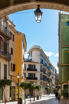 Spain, Mallorca, Palma de Mallorca, Lantern hanging from arch over city street