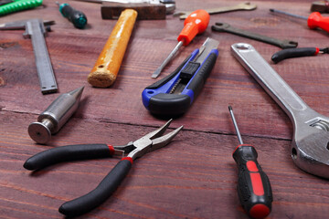 Variety of locksmith tools for repair work on wooden background.