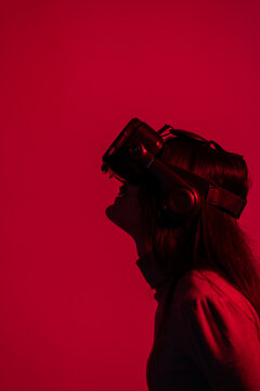 Woman using virtual reality headset against red background