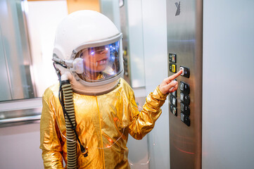 Boy wearing space suit pressing buttons in elevator