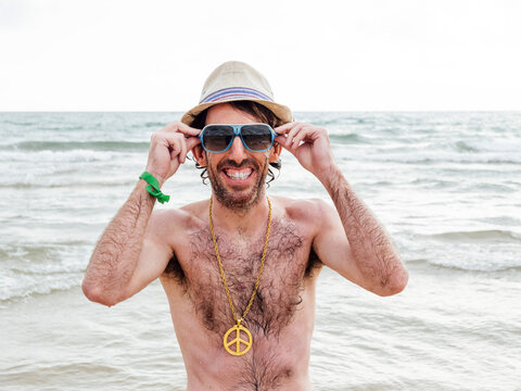 Portrait of smiling man with hat and sunglasses on the beach