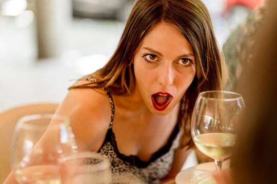 Surprised young woman sitting in restaurant